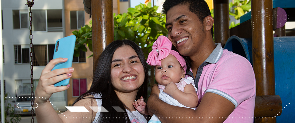 Familia sonriendo frente a la cámara del celular