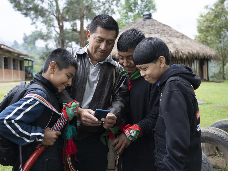 Grupo de jóvenes mirando la pantalla de un celular